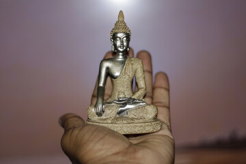 Serene Buddha Statue on hand empty colorful backdrop with copy space, yoga, meditation and...