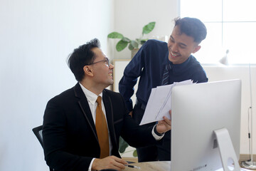 Two Male Business Partners Discuss Business Plans and Brainstorming Ideas In Office