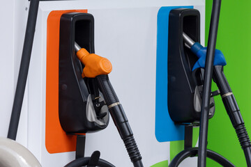 Two gas pumps with orange and blue nozzles