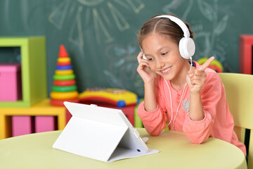 Cute little woman with tablet and headphones