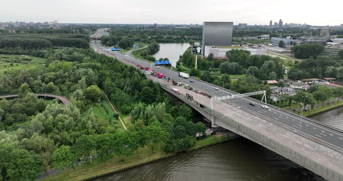 the traffic on A10 highway surrounded by dense trees spaces at the daytime in Amsterdam, Netherlands