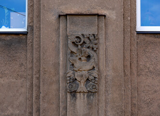 criatura con decoración floral en la fachada principal