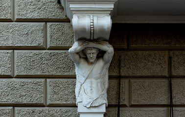 cariátide masculina blanca bajo el balcón