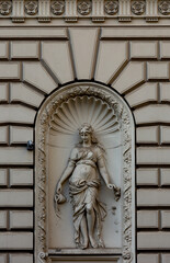 personaje femenino con jarrón y rosa en la hornacina