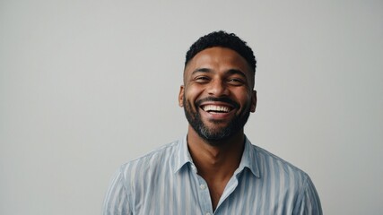 Fototapeta premium A cheerful man smiling against a neutral background, showcasing happiness and confidence in a joyful moment