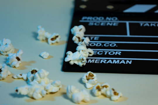 popcorn on a black wooden clapperboard with white stripes, cinema concept
