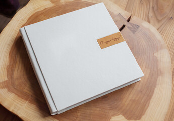 White photo album in leather cover on wooden table