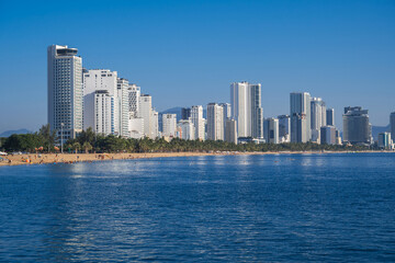 Naklejka premium Panorama of the resort Nha Trang city in Vietnam with a sandy beach by the sea and skyscrapers of hotels in summer