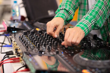 close-up of a DJ mixing music on a mixing console