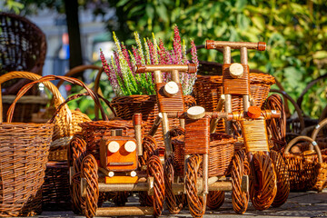 wicker baskets and other decorations at a village market. wicker cars for children © Adam