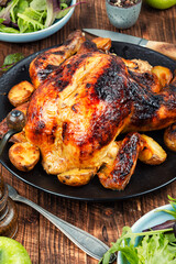 Roasted, baked chicken with potatoes and apples.