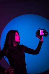 A woman enjoys the world of virtual reality in VR glasses. Virtual reality headset. Artificial intelligence. VR glasses concept. Vertical photo