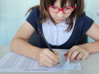 Schoolgirl cheating on exams at school and cheating on a cheat sheet concept