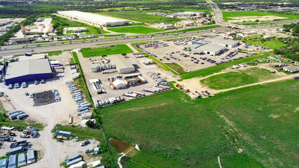 Busy interstate highway I-35 with overpass in industrial zonings manufacturer warehouse near large...