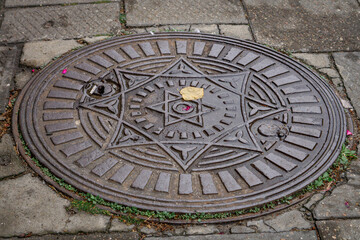 old antique cover, manhole manhole in the city on the sidewalk.