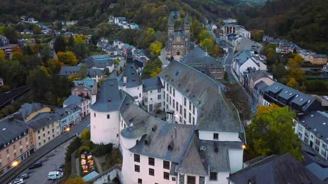 Aerial drone Shot of town CLervaux on the north of Luxembourg. Twilight evening scene with Castle and Cathedral