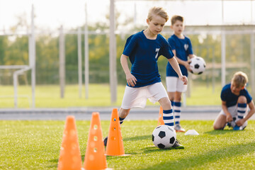 Children in soccer practice. Boys attending football training on the school field. Kids in physical...