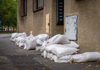 sandbags lying on the sidewalk in front of the entrance to the tenement house. sandbags as protection against flooding and water entering the building.
