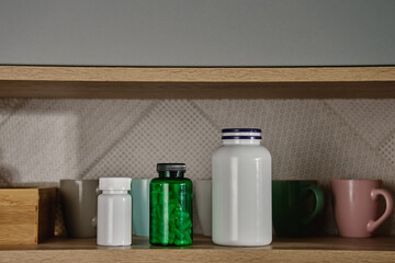 Kitchen cabinet with medical containers, pills and vitamins on shelf. Taking pills or vitamins for...