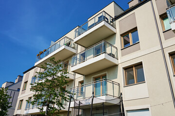 Modern apartment building with balconies and green trees on sunny day. Residential complex in Wroclaw, Poland. Mortgage in real estate