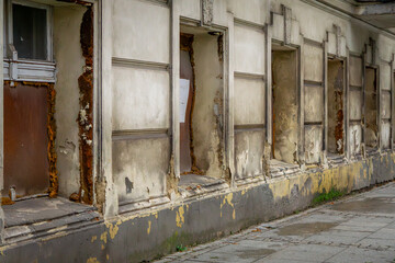 an old ruined, dilapidated tenement house in the city center with boarded up windows