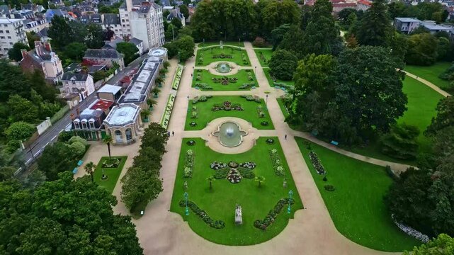 Drone flying over Thabor gardens with fountains and flower beds, Rennes in France. Aerial forward