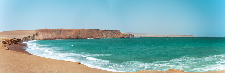 A beautiful beach with a rocky cliff in the background. Panoramic view Paracas, Peru