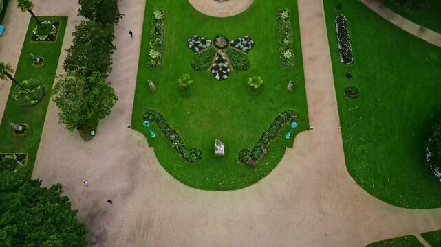 Drone flying over Thabor gardens with fountains and flower beds, Rennes in France. Aerial top-down forward