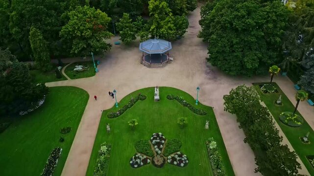 Thabor gardens with bandstand and flower beds, Rennes in France. Aerial drone backward