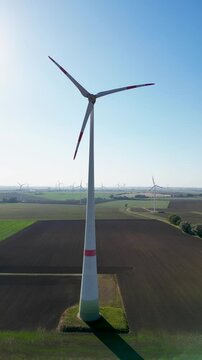 Windturbinen in herbstlicher Landschaft im Gegenlicht. Aufnahmen eines Windparks zur Erzeugung erneuerbarer Energie. Aerial, Hochformat