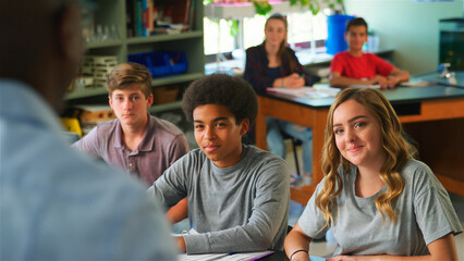 Close Up Of Male High School Tutor Standing And Teaching Students In Biology Class