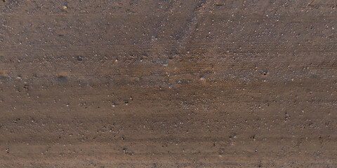 view from above on texture of dry muddy road with tractor tire tracks in countryside