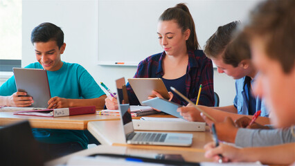Class Of Multi-Cultural High School Pupils Using Digital Devices Working At Desks