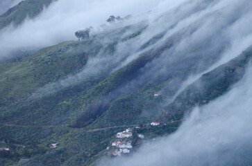 Sea of clouds falling over the Tejeda Caldera and village of Cuevas Caidas in the foreground. Tejeda. Gran Canaria. Canary Islands. Spain.