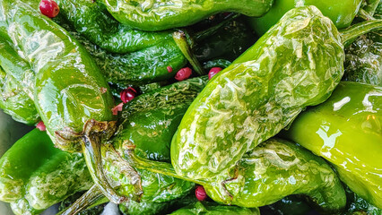 Close up of typical rustic spanish plate Pimientos de padron. Yammy green grilled pepers with spices, starter tapas. Vegan organic light summer meal