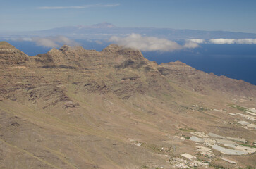 Naklejka premium La Aldea valley, cliffs in the Special Natural Reserve of Guigui and island of Tenerife in the background. Gran Canaria. Canary Islands. Spain.
