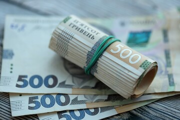 Many five hundred hryvnia money bills lies on wooden background. Ukrainian national currency close up