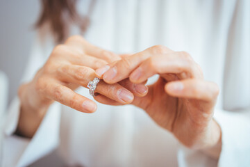 Close-Up Of Hands Adjusting An Elegant Diamond Ring On Finger