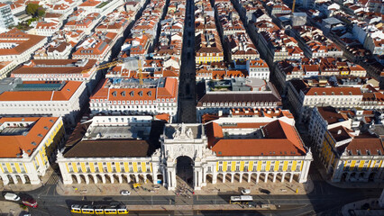 Uma imagem icónica do Terreiro do Paço (também conhecido como Praça do Comércio), situada na Baixa Pombalina, em Lisboa. A ampla praça está rodeada por majestosos edifícios de cor amarela com arcadas 