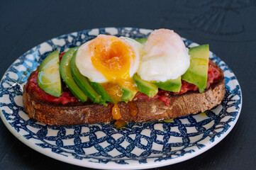 A delicious and healthy avocado toast topped with perfect poached eggs.