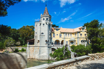 Fototapeta premium A beautifully preserved, castle-like building with a tall stone tower, arched windows, and intricate details, nestled among lush greenery