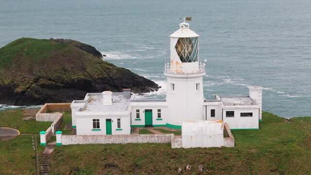 Strumble head lighthouse flashing tower beacon overlooking rugged Pembrokeshire coastal mainland