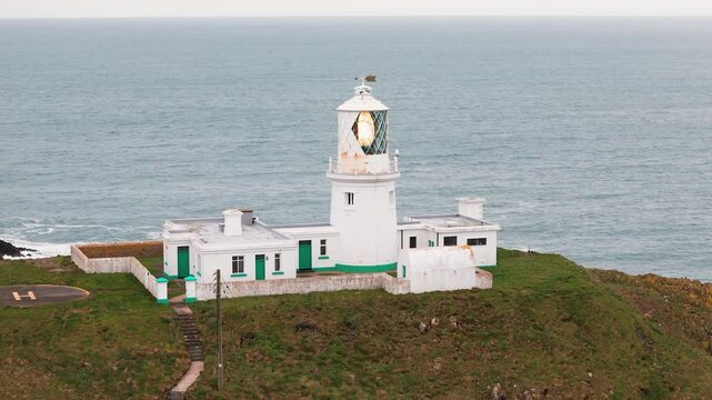 Strumble head lighthouse tower beacon flashing across rugged Pembrokeshire coastal mainland