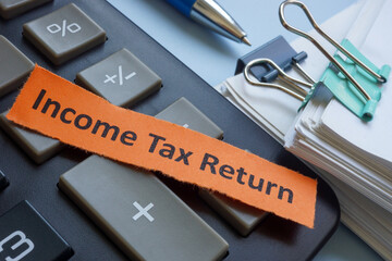 Income tax return with a label, calculator and papers.