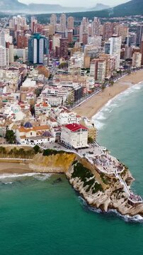 Vertical aerial view of Benidorm city. View of old town center, famous Plaza Santa Ana and Mirador del Castell - Balcony of Mediteranea. Famous travel destination in South of Spain. Drone circling