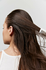 Hair care, hair styling, hair treatment, healthy hair, beauty routine, personal care, grooming, close up of woman brushing her long hair against a light gray backdrop