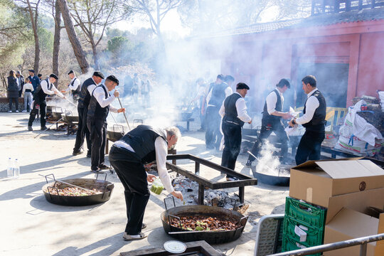 Sant Fruitos de Bages, Spain - February 19, 2023: Cooks making rice paellas in a village competition