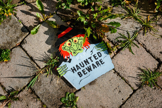 Haunted Beware Sign Fallen on a Paved Driveway on Halloween
