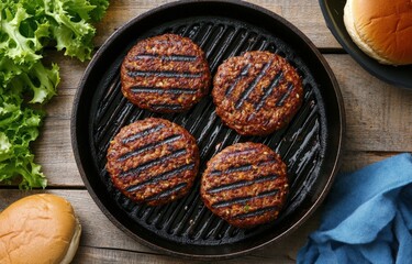 Grilled patties cooking on a cast iron skillet with fresh burger buns and lettuce nearby