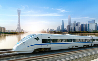 Naklejka premium High-speed rail speeds on Bridges and the modern city skyline of guangzhou, China